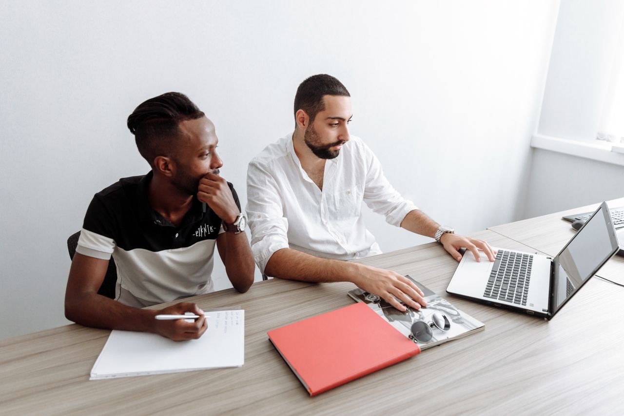 Two professionals engaged in a strategy meeting at a sleek office desk, fostering teamwork and collaboration.